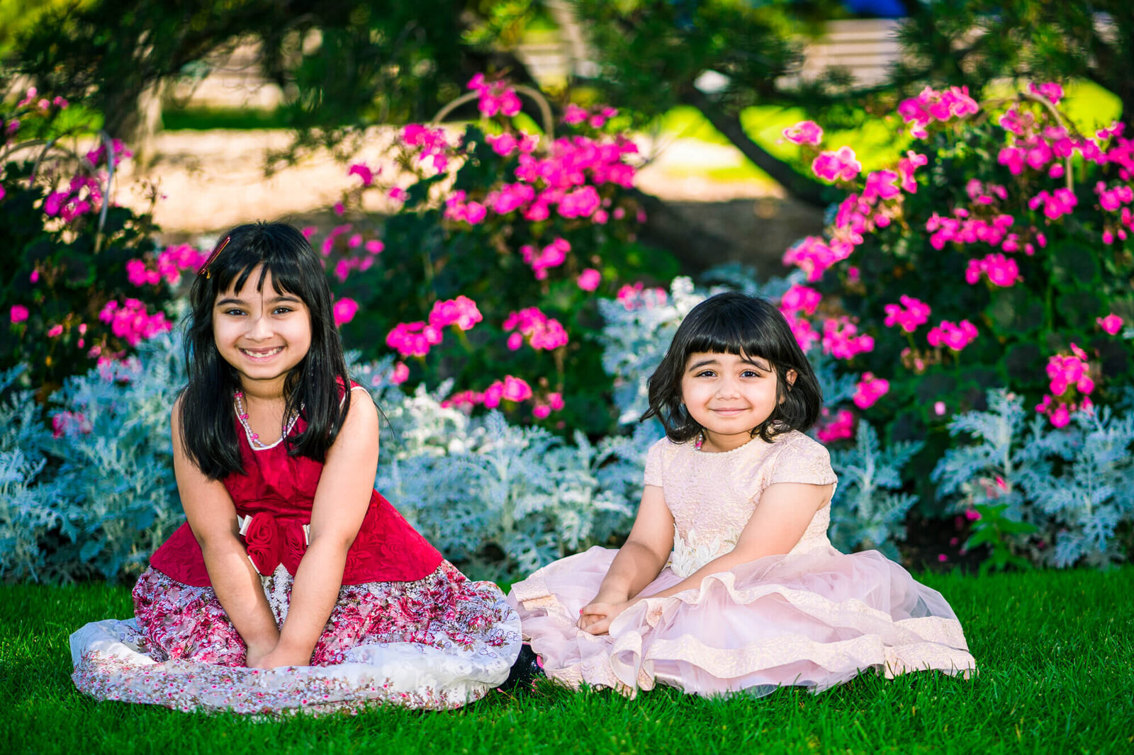 young sisters  posed infront of flowers