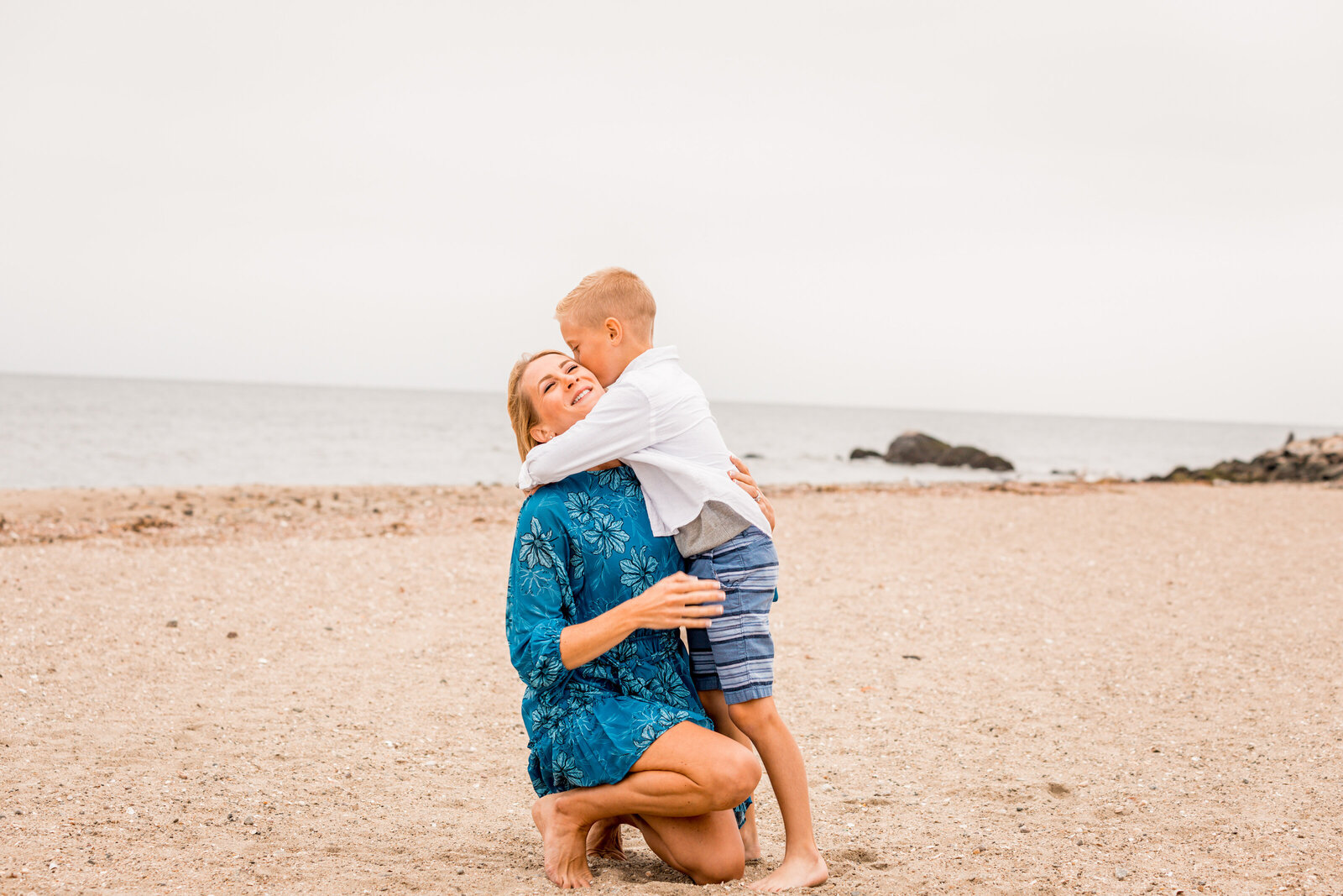 mom with son hugging on the westport beach