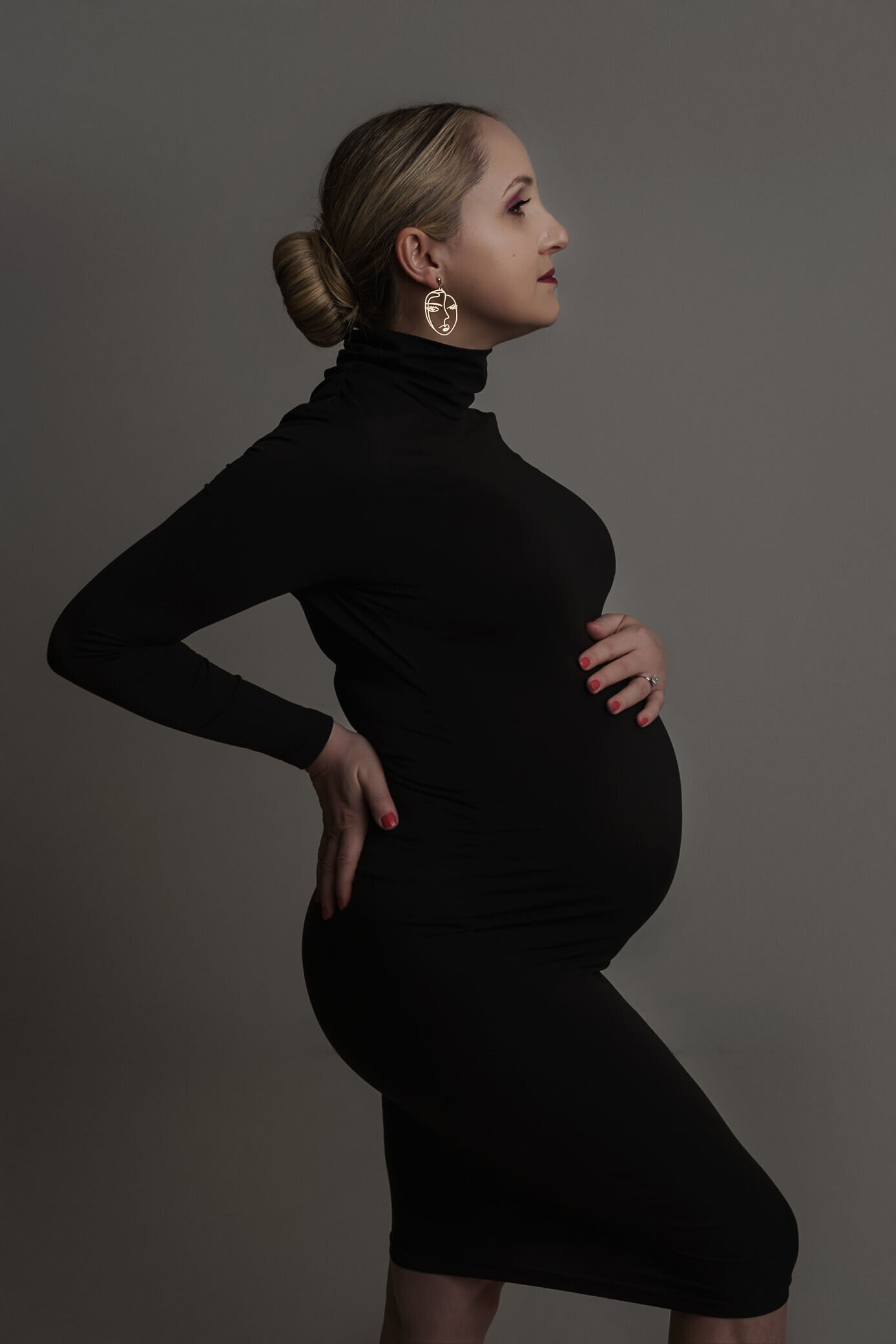 pregnant mom wearing black tight turtle neck dress
