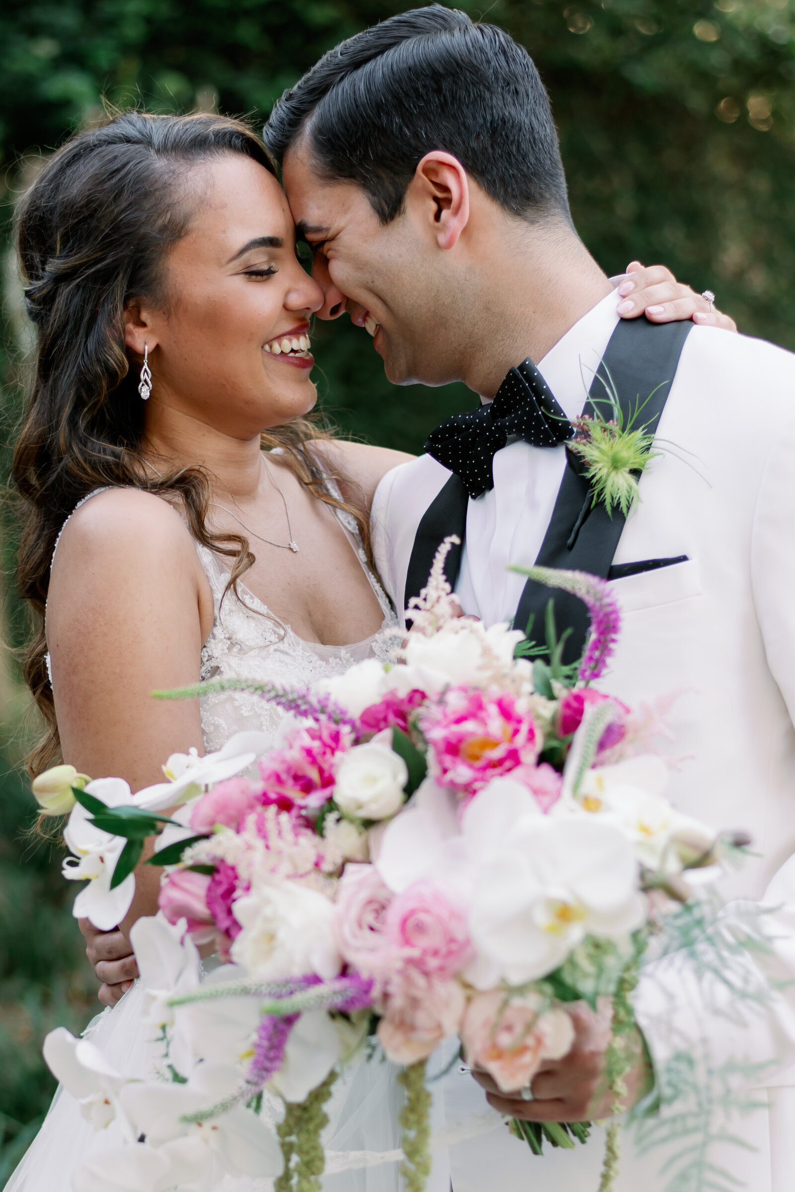 bride and groom touching foreheads and smiling