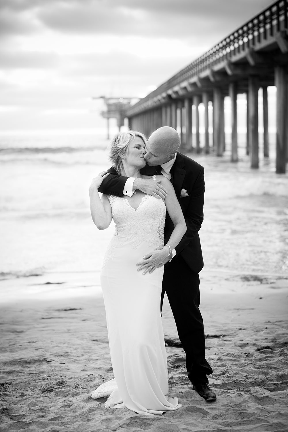 black and white bride and groom with pier