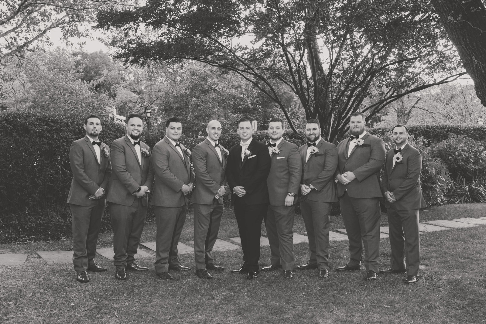 black and white photo groom with groomsmen from wedding at Three Village Inn