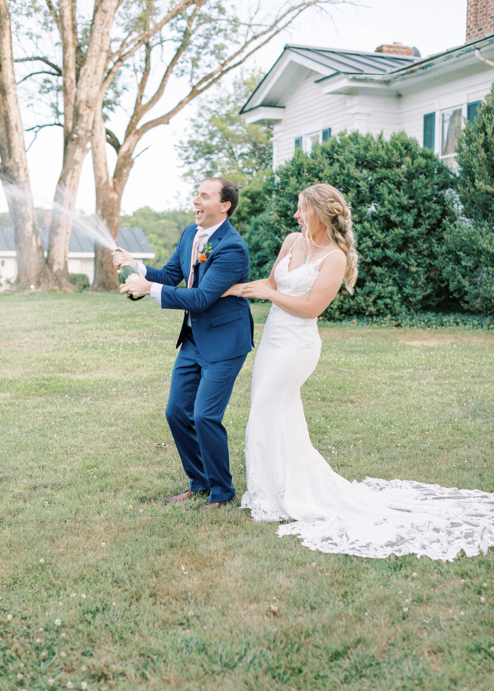 Bride and groom pop a champagne bottle