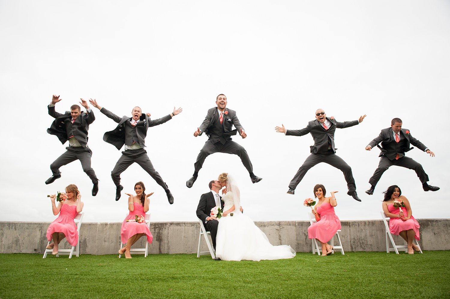 groomsmen jumping in the air at ocean view room