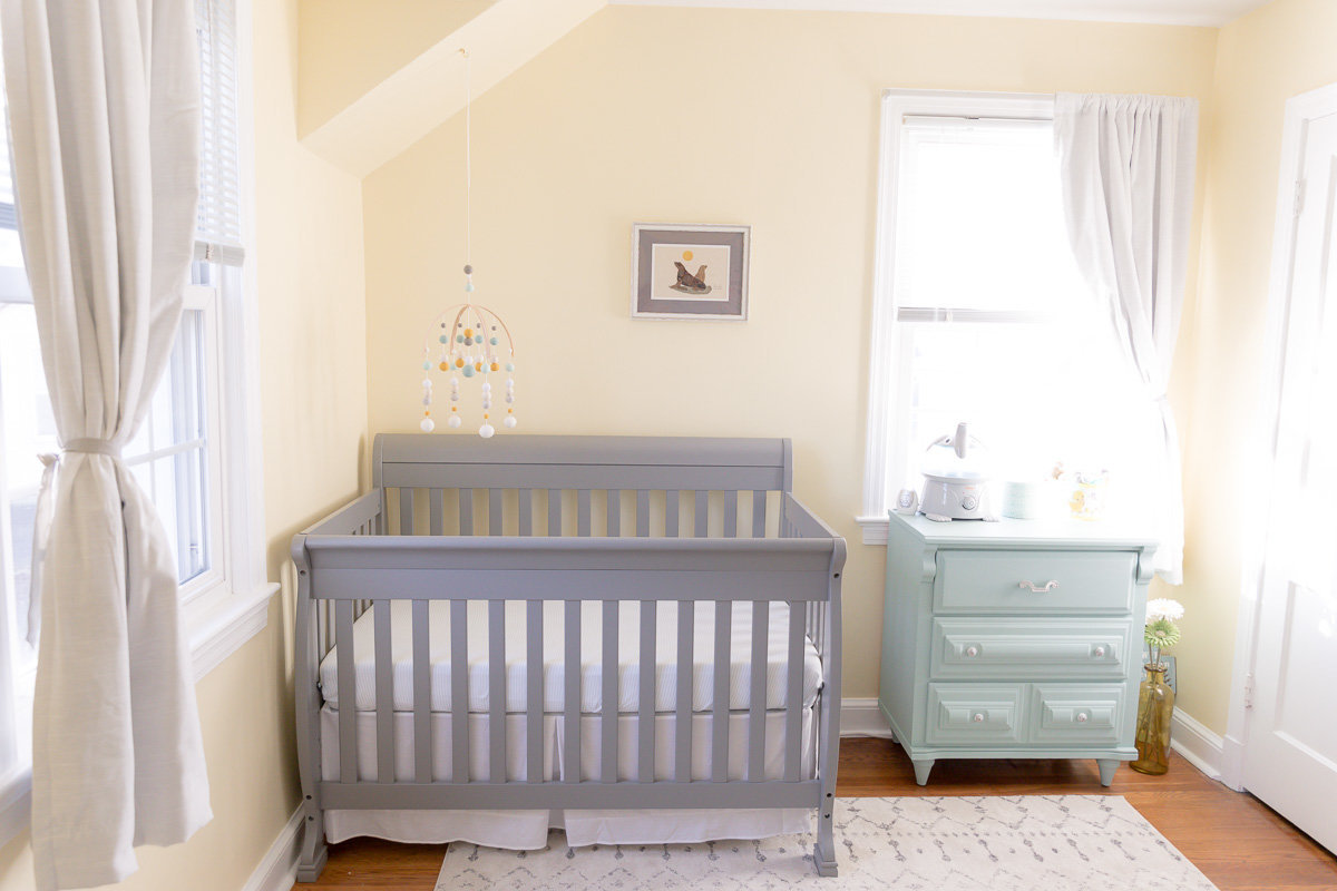 gray crib teal dresser hanging mobile in bright natural light newborn nursery