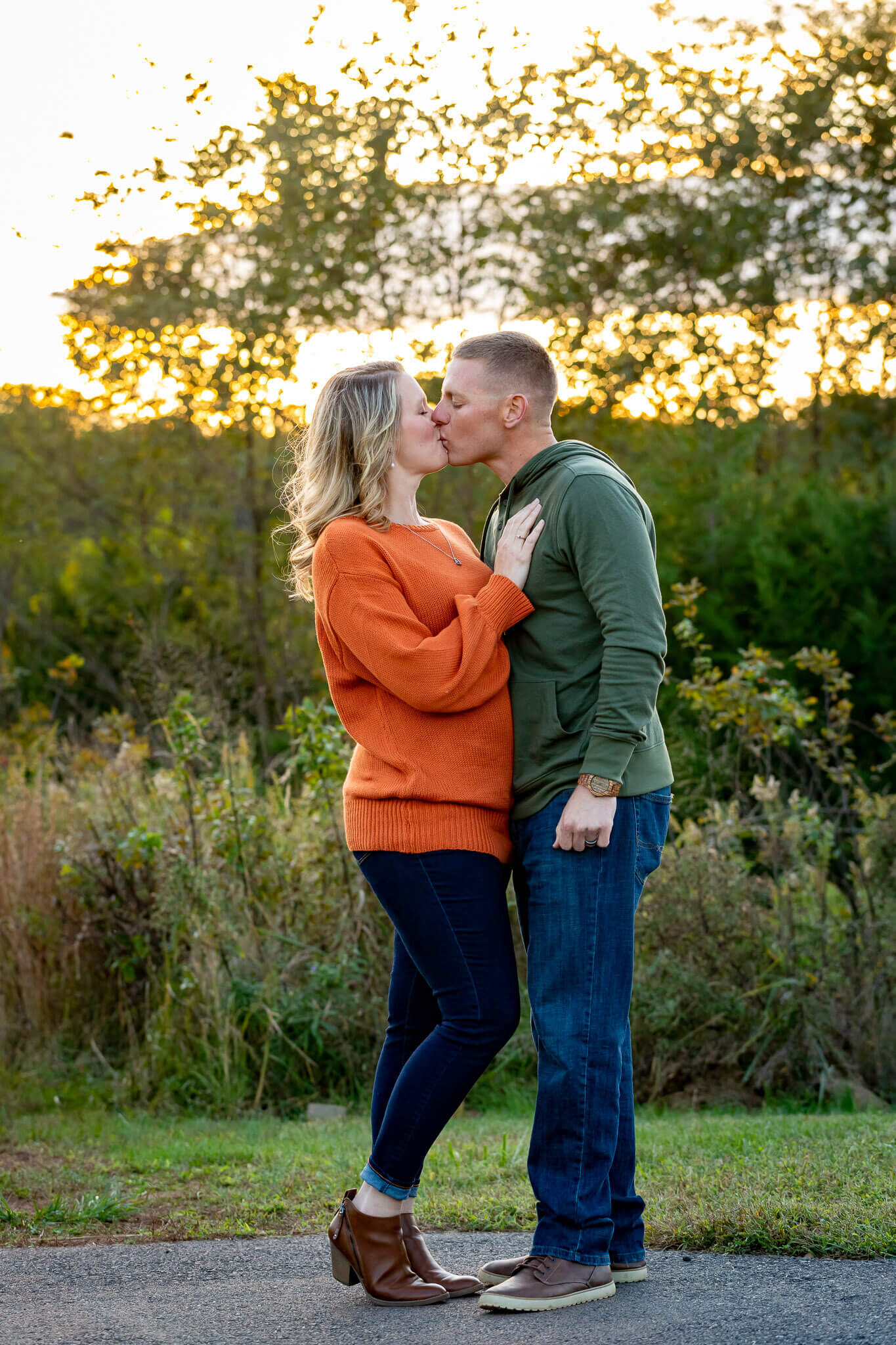A mom and dad kissing at a Northern Virginia park at sunset.