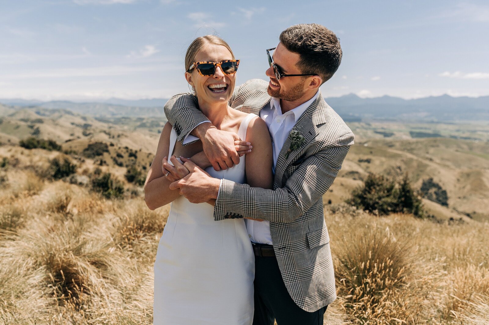 bride and groom on top of wither hills blenheim photo spot wedding day wearing sunglasses tweed blazer white dress emilia wickstead