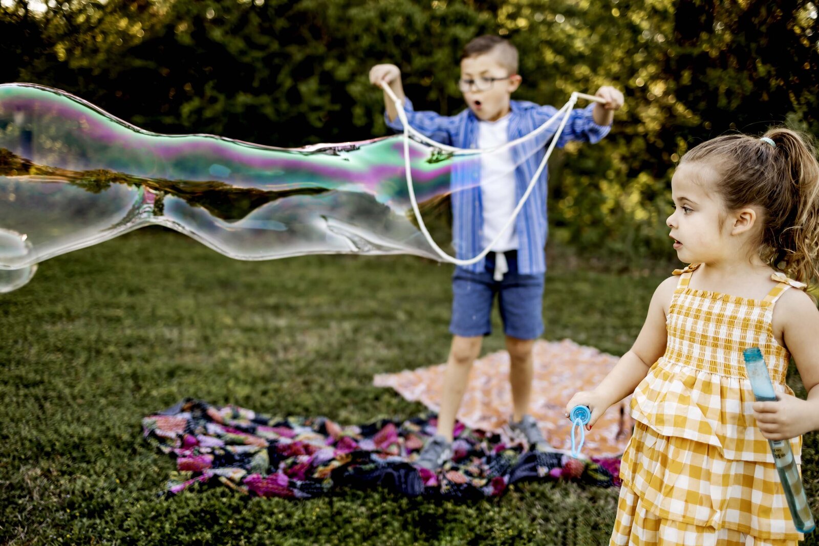 two children from southlake texas play with giant bubbles in the park in southlake texas