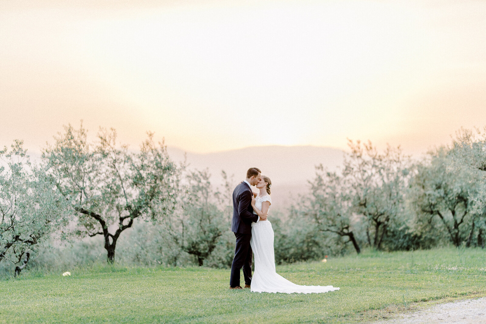 Bridal couple kissing at sunset in Tuscany