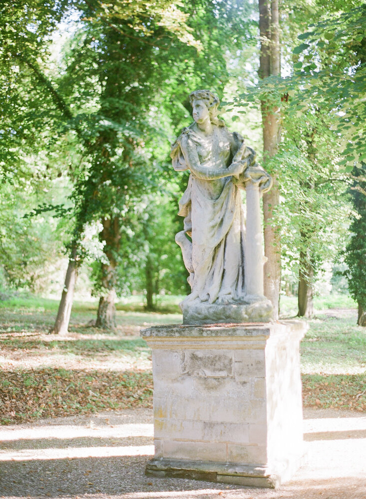 Large marble statue sitting in French parkland