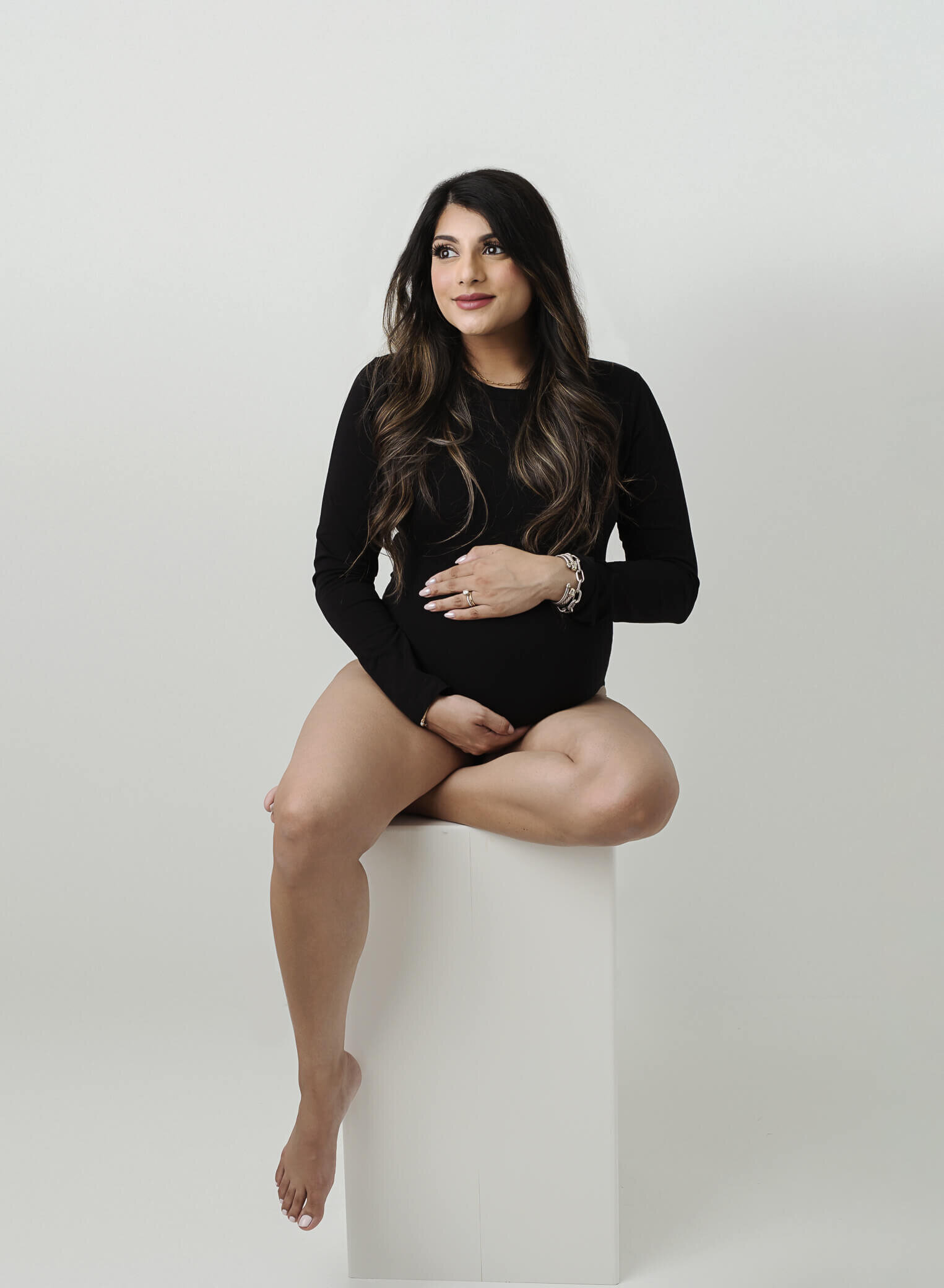 pregnant mom wearing black body suit, on a white background