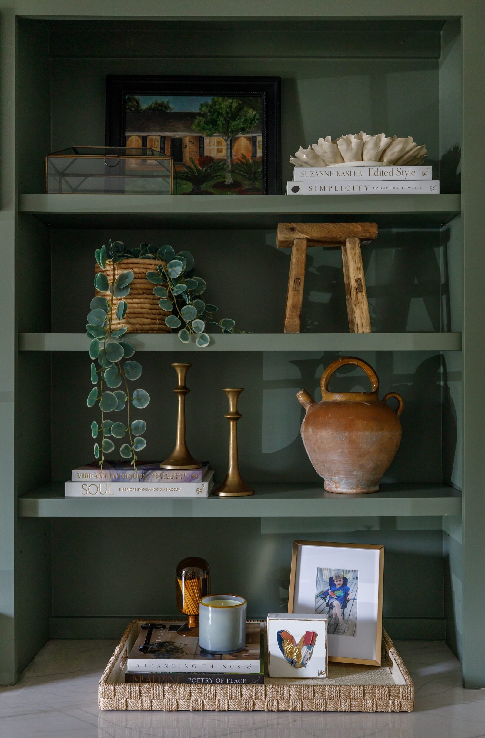 vision and hammer styling shelf on dark green shelf with gold candle sticks