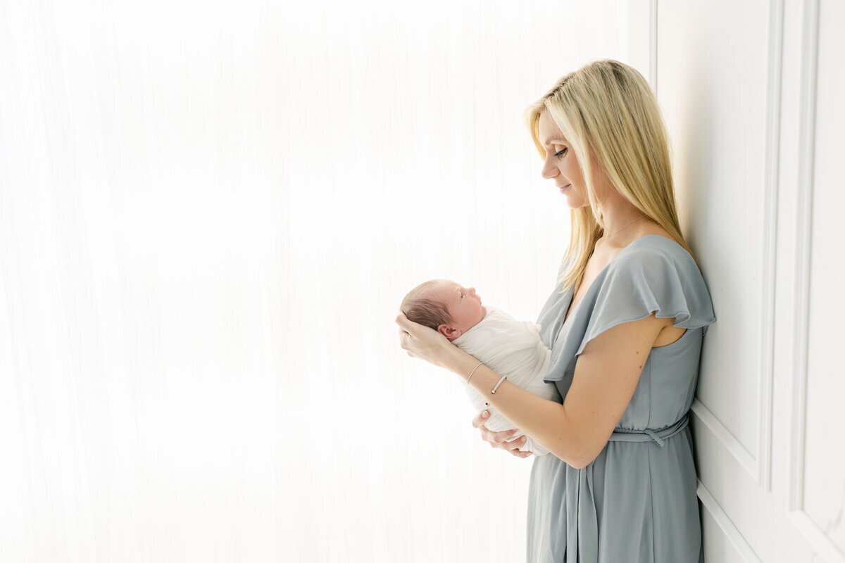 Mom looking at newborn baby, taken by best newborn photographers nj
