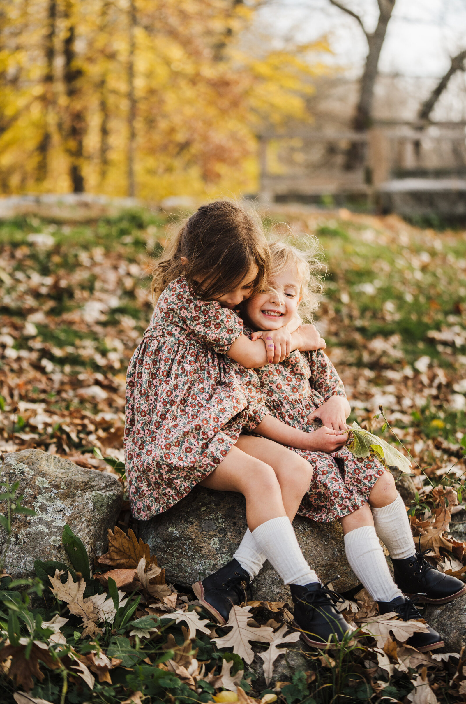 sisters in matching outfits hug during boston family photos