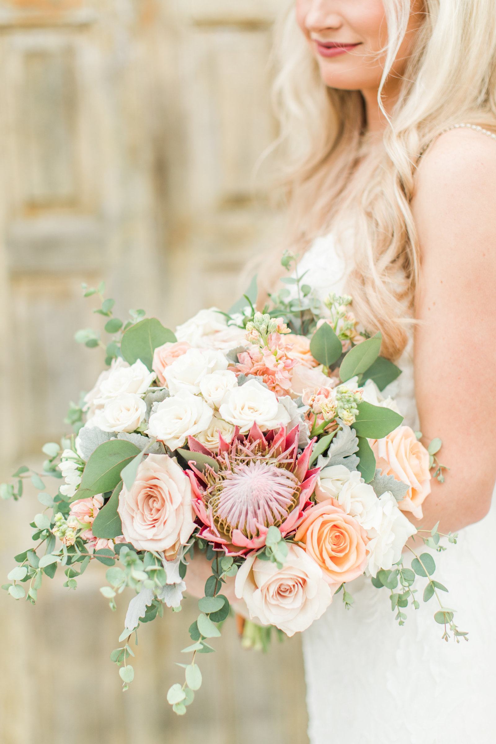 Bouquet with peach roses and pink proteas