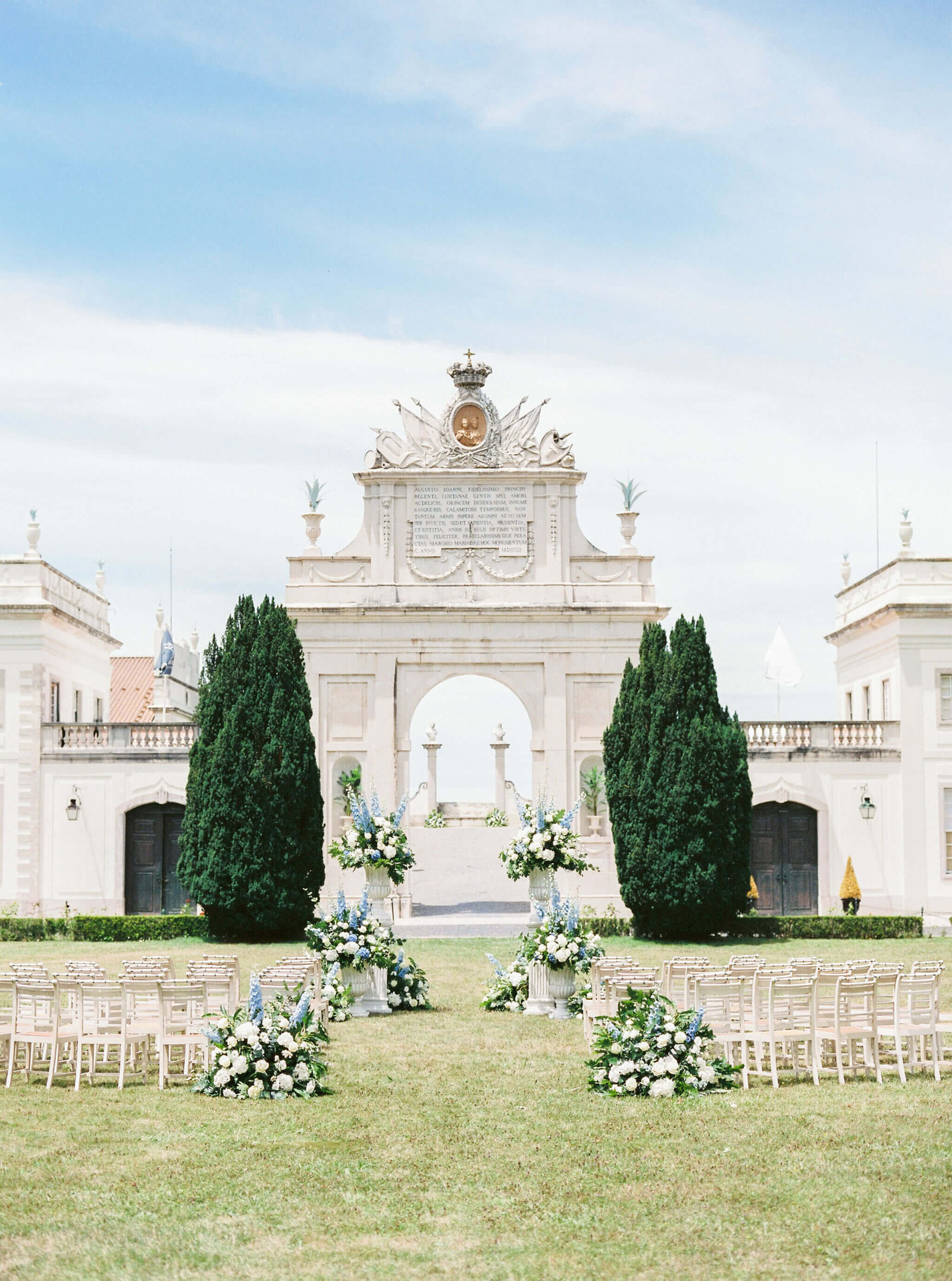 Wedding ceremony in tons of white and blue at Seteais Palace arch wedding