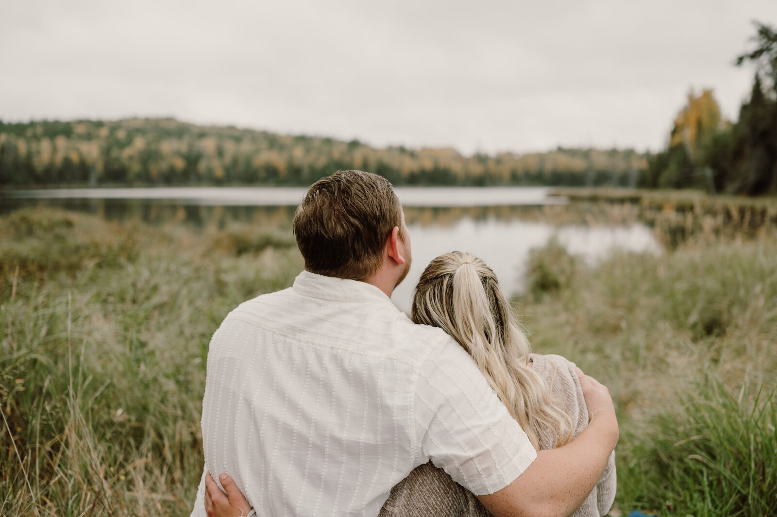 Fall engagement poses inspiration - woman and man sit and look at the view