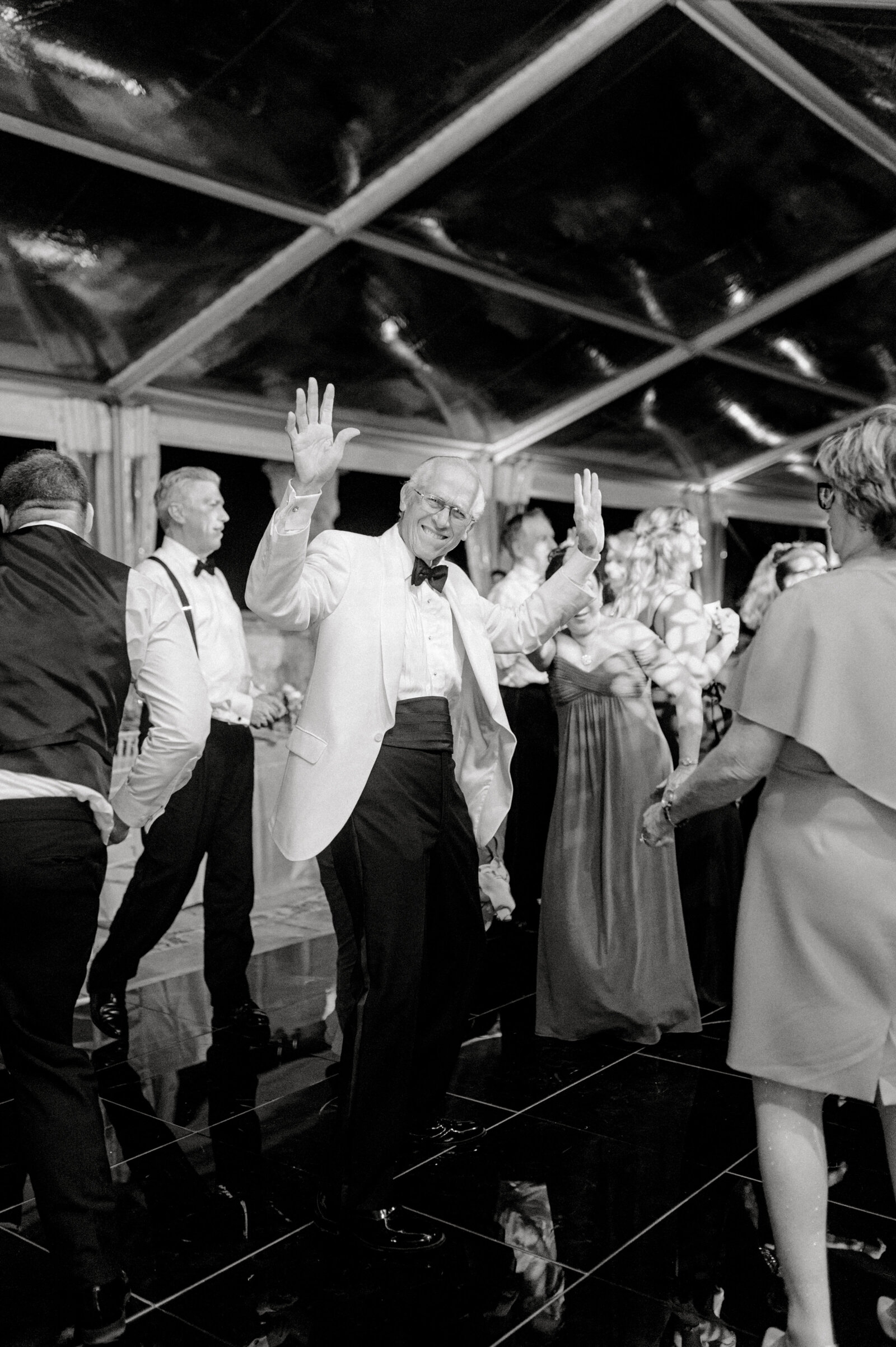 black and white image of guests dancing at wedding reception