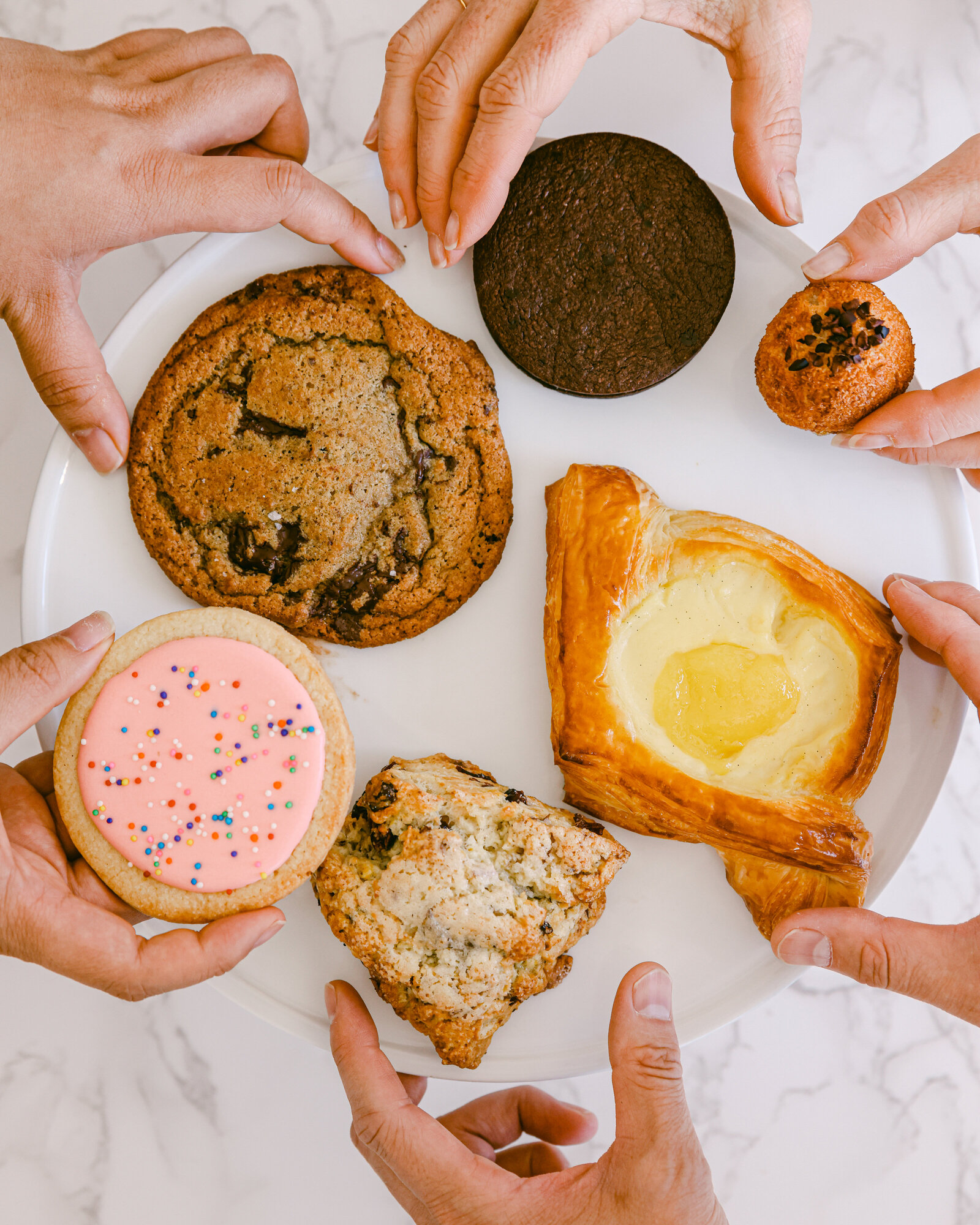 friends picking up pastries colorful flat lay