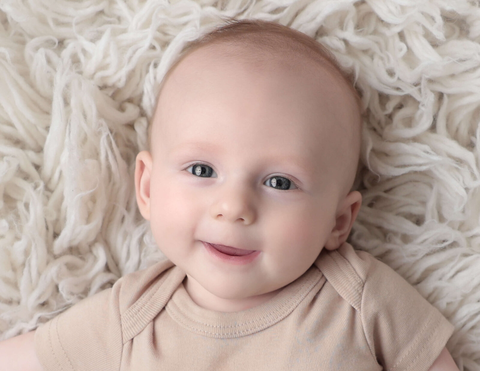 Sweet baby boy smiling at at studio in Rochester, Ny.