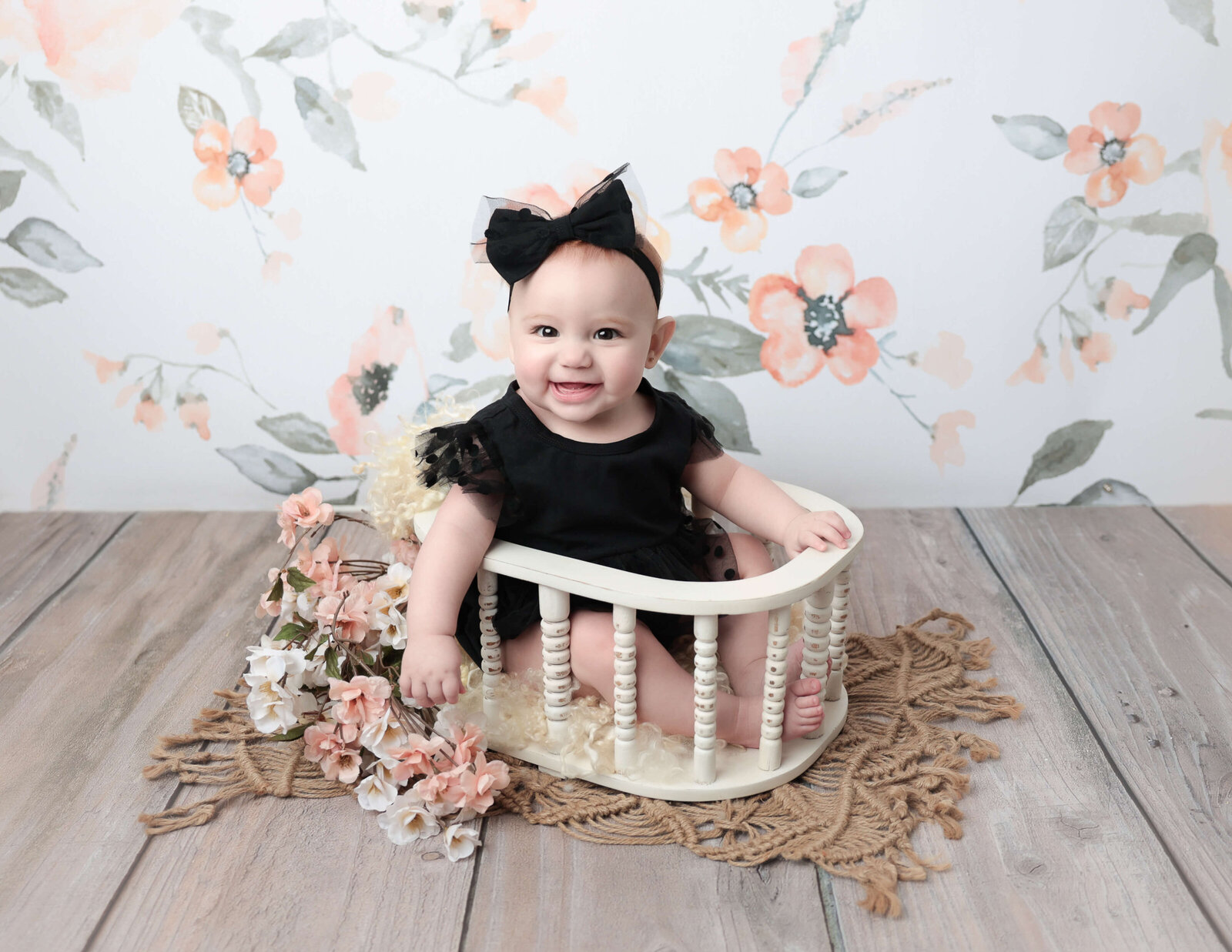 Six month old girl smiling in a basket at our Rochester, NY studio.