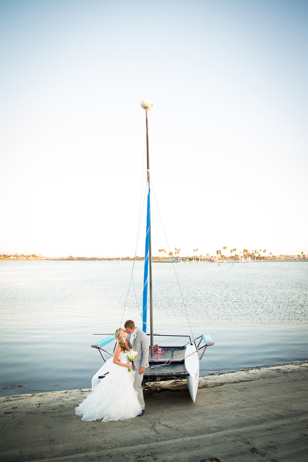 bride and groom with sailboat catamaran