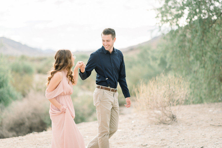 Tucson Desert Engagement Session Photo of Couple Wearing Blush Pink Gown and Navy Blue Shirt Walking Side By Side | Tucson Wedding Photographer | West End Photography