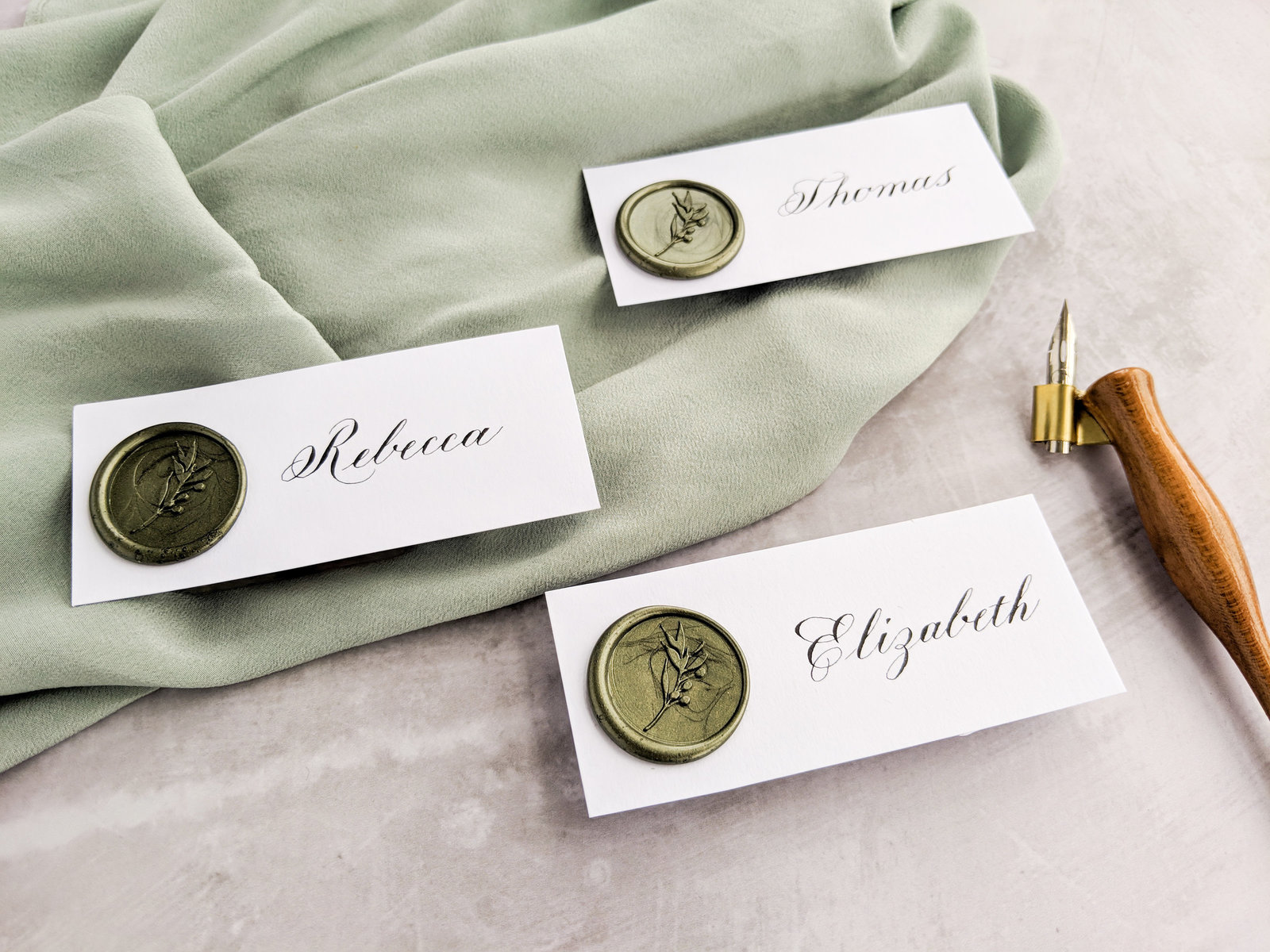 Copperplate calligraphy place cards with olive green wax seal