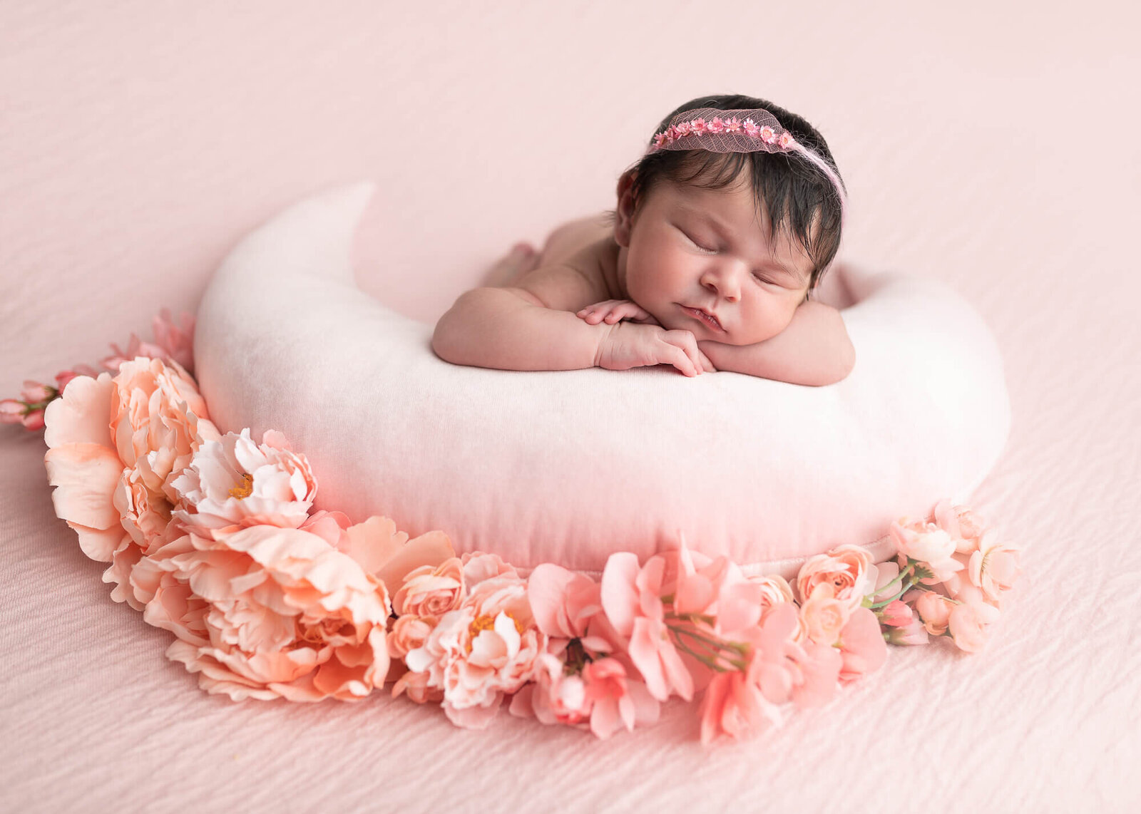 Baby girl photographed on pink with flowers