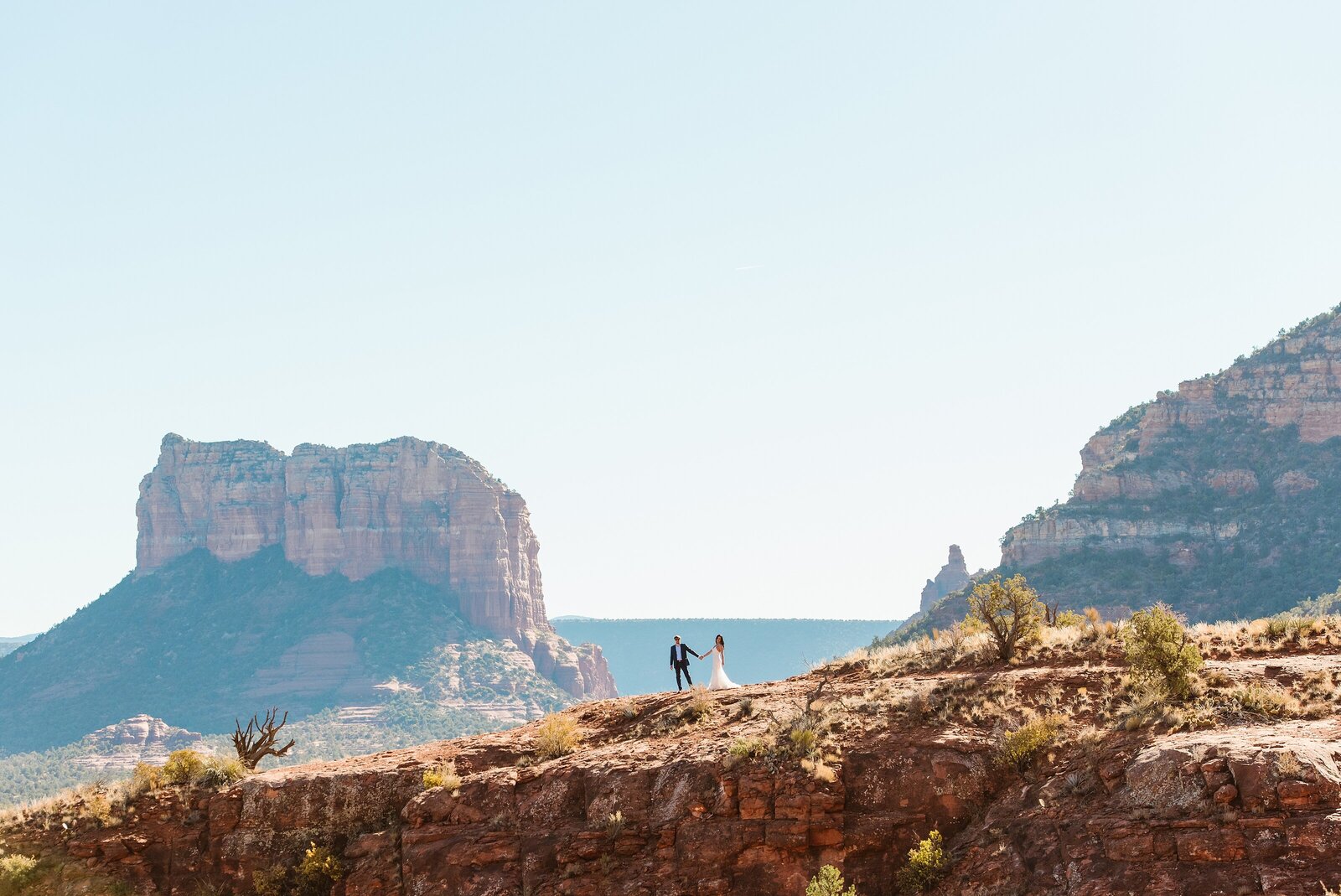 photo of couple eloping in the desert with large mesa views in the background