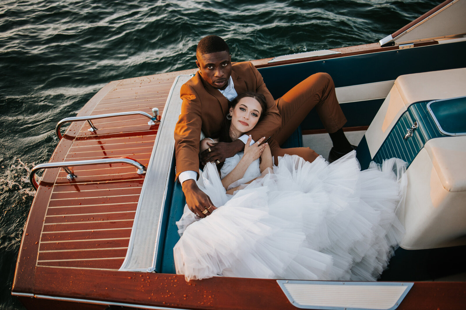 Couple cuddling on a boat on Lake Tahoe on their wedding day.