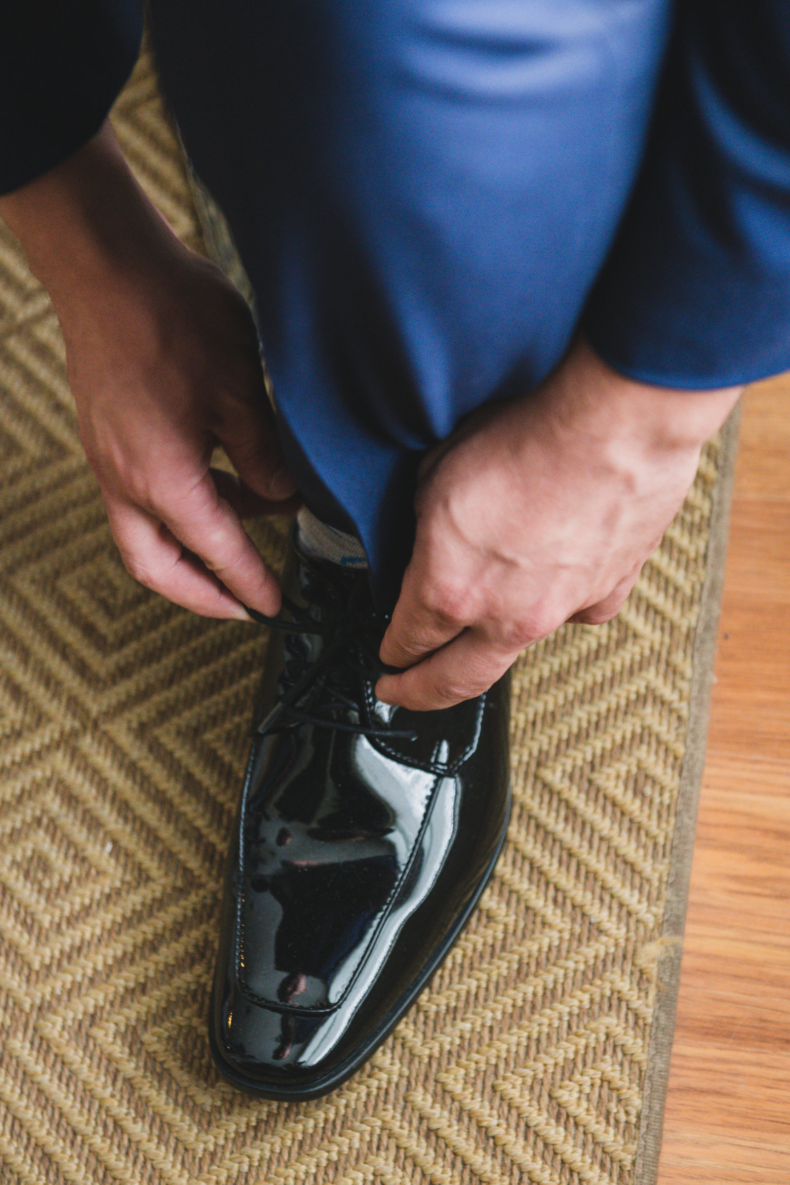 photo of groom tying his shoe laces from wedding at Three Village Inn