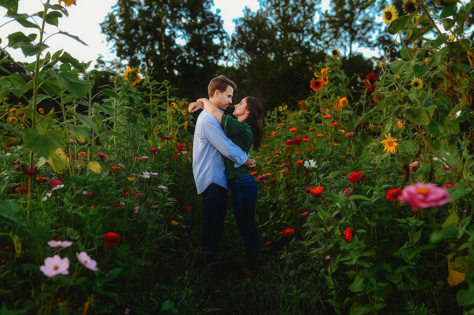 A couple in love poses for Engagement Photos in a field of flowers in Asheville, NC.