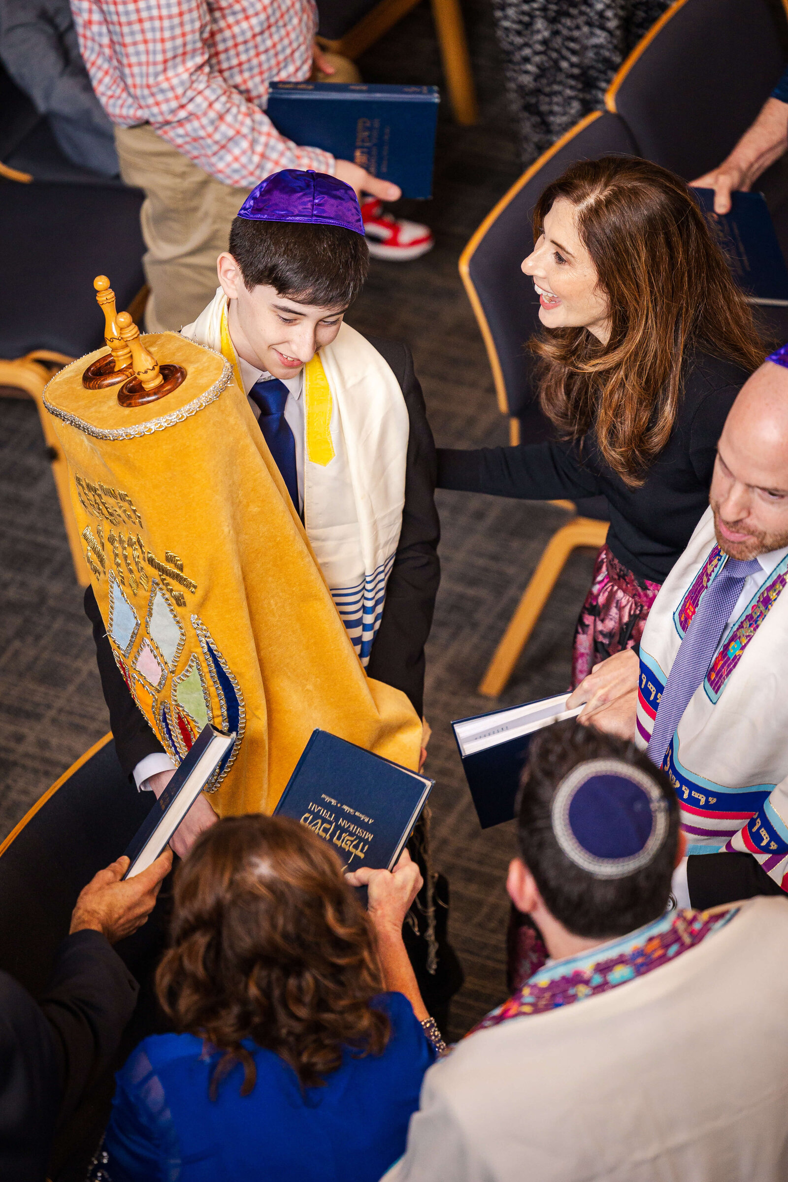 A teen boy holds the torrah scroll while celebration with mom and dad in the Temple taken by a Bellevue Bar and Bat Mitzvah Photography specialist