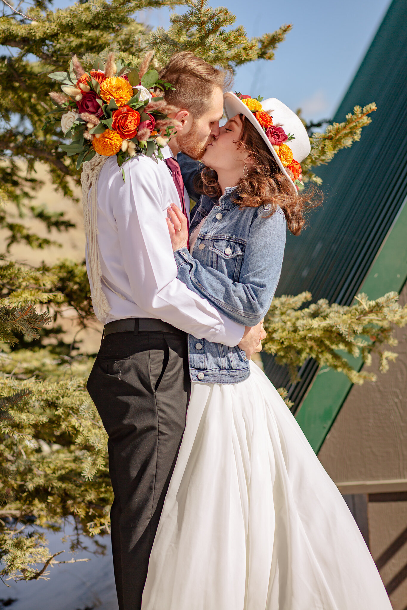 Bride and groom kiss outside of their a frame cabin