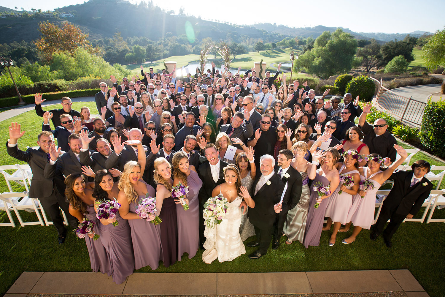 full wedding party with arms up