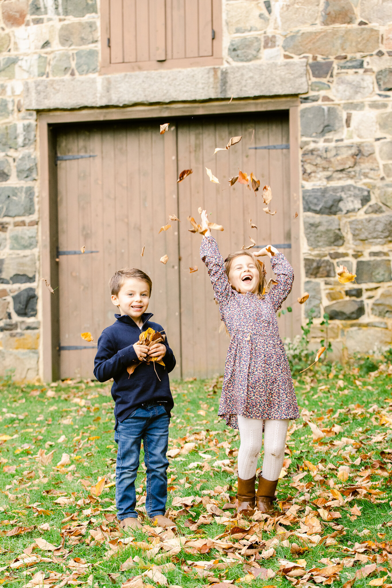 brother and sister throwing leaves