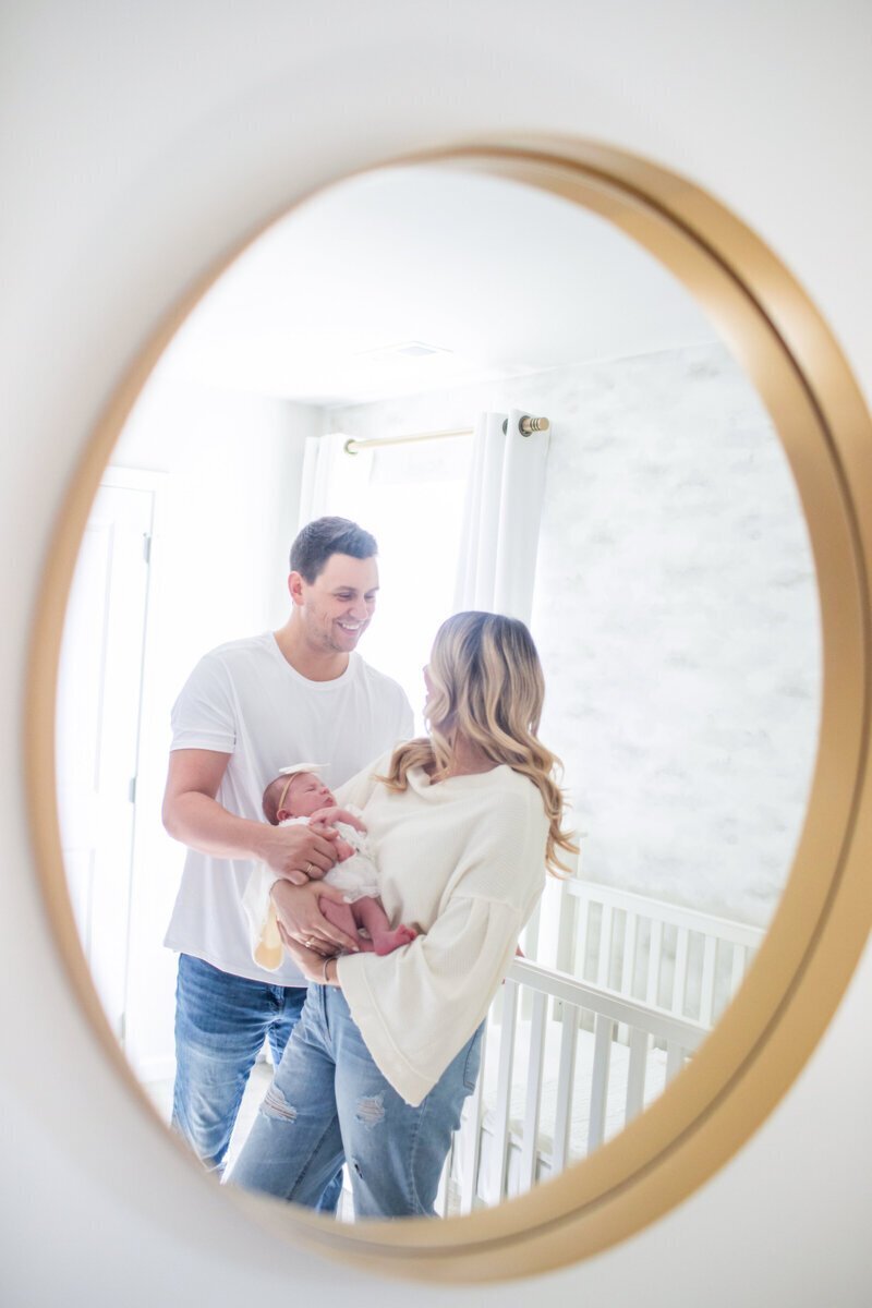 Parents in nursery holding newborn baby by newborn photography in new jersey
