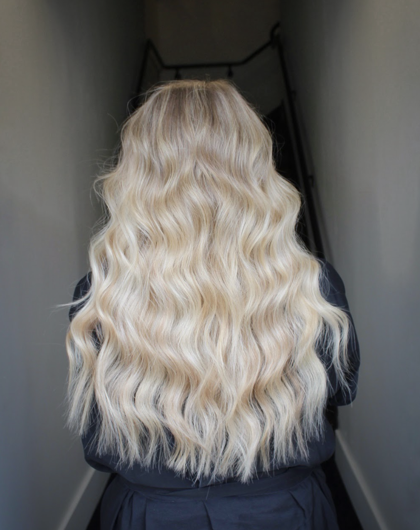 Luxurious full-bodied platinum blonde curls cascading down the back