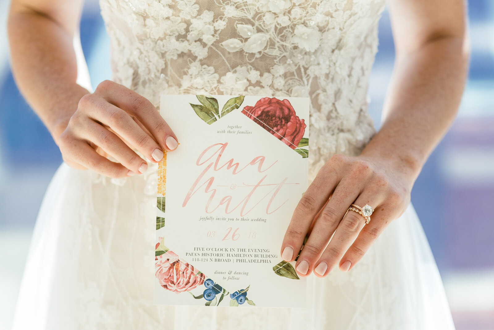 brides hands holding modern wedding invitation