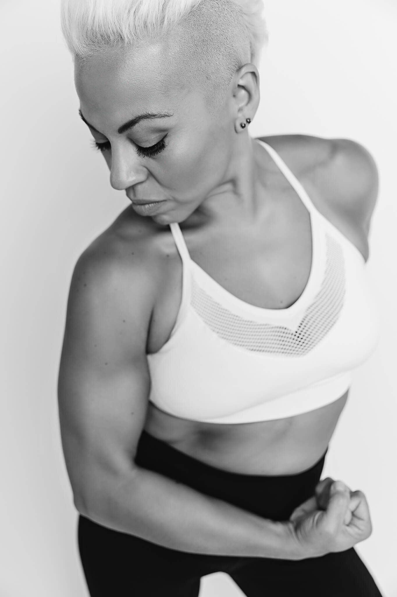fitness figure is showing her muscles for a branding photoshoot in a black and white picture