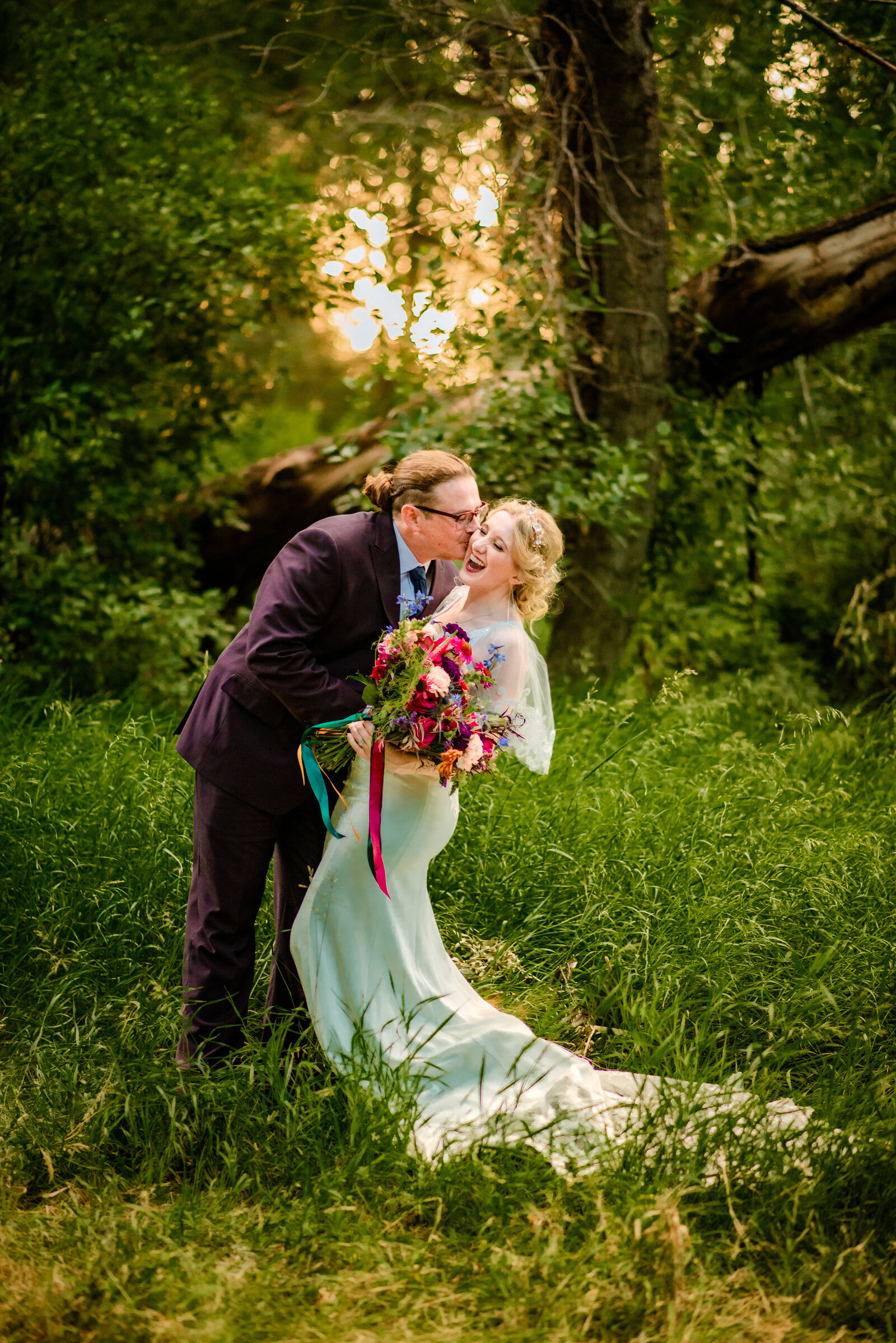 Jackson Hole wedding photographers capture outdoor bridal portraits while couple laughs together