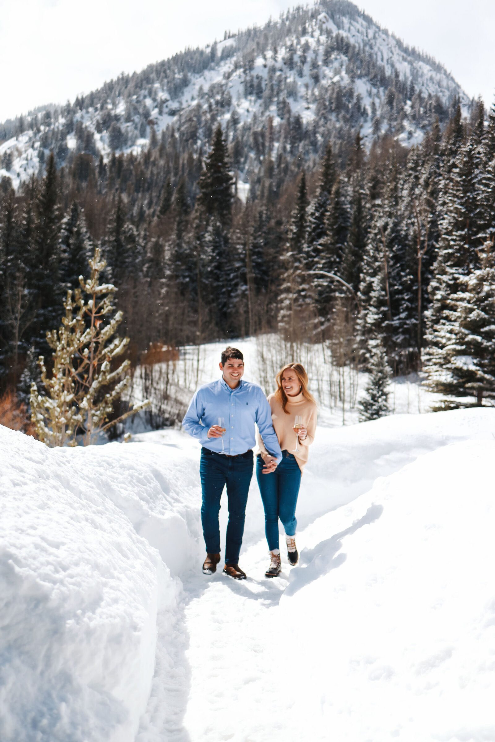 A couple walks through the snowy mountains together after their surprise proposal at the Pine Creek Cookhouse.