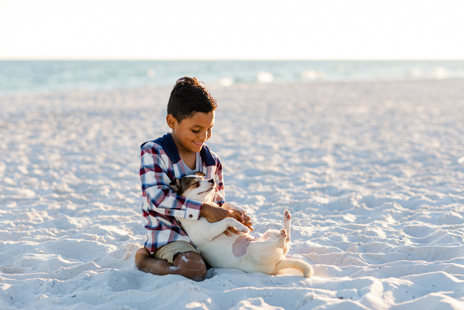 Boy playing with his dog during family photo session at Pensacola Beach Dog Park.