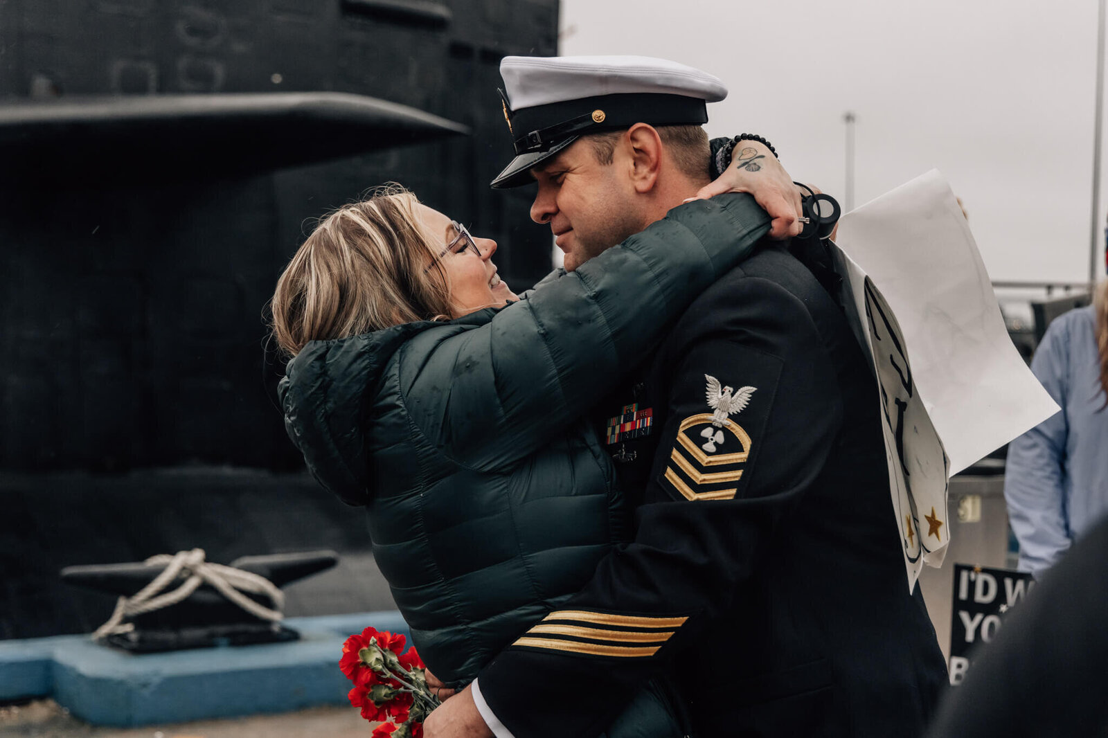 Naval Chief Petty Officer embraces spouse at emotional USS Newport News homecoming at SUBASE New London in Groton CT