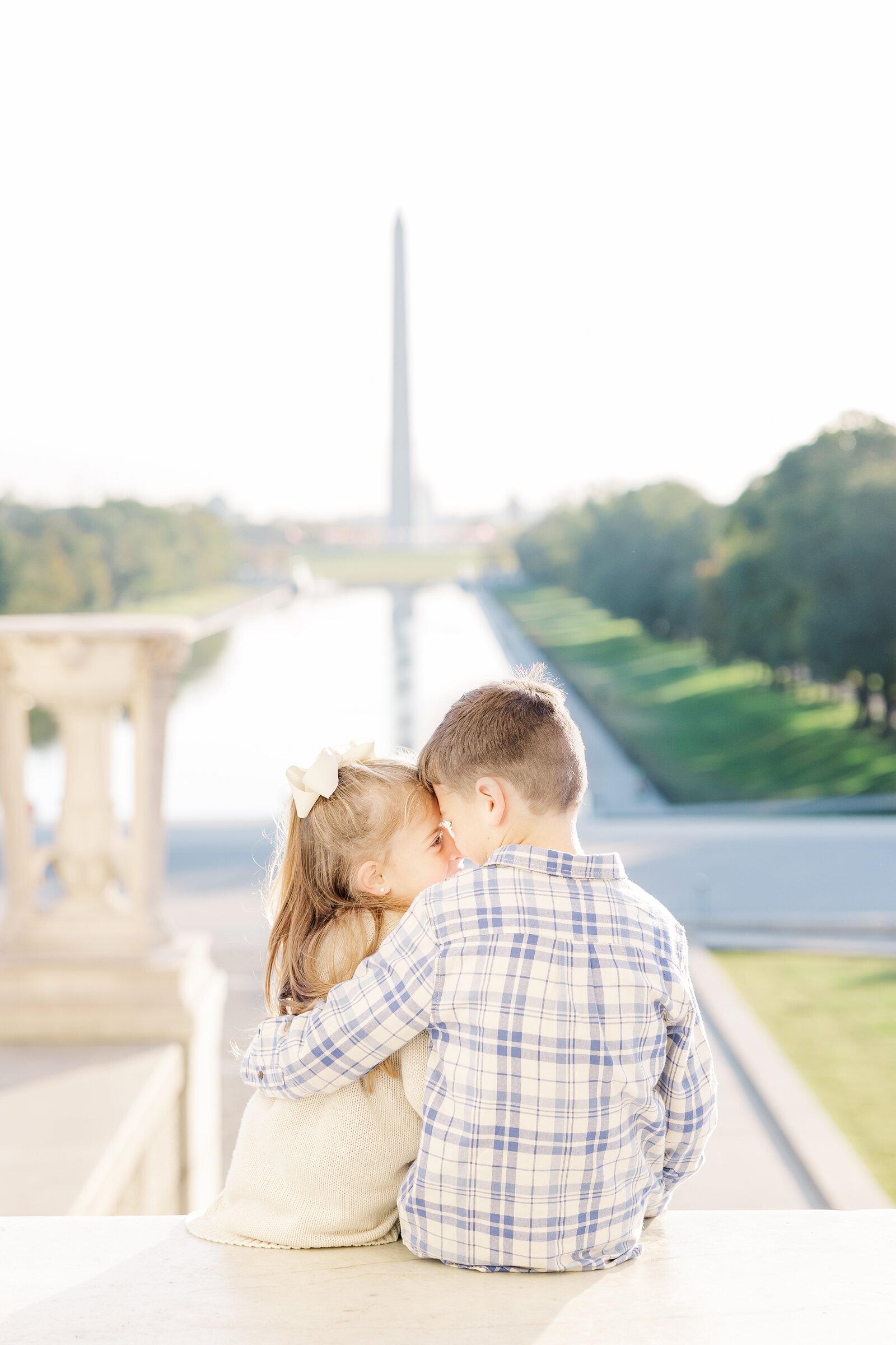 Brother and sister sitting nose to nose overlooking the Washington Monument