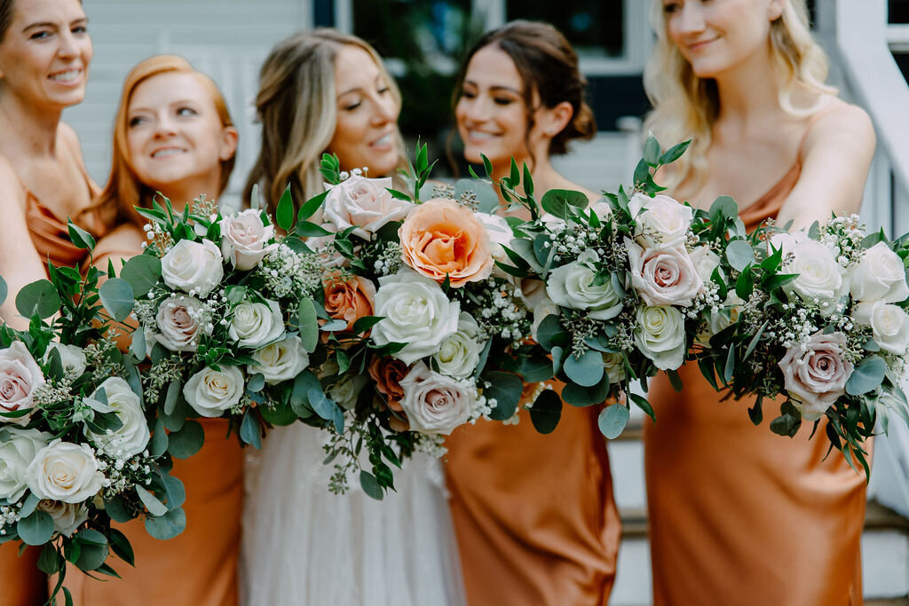 bride with bridesmaids showing flowers