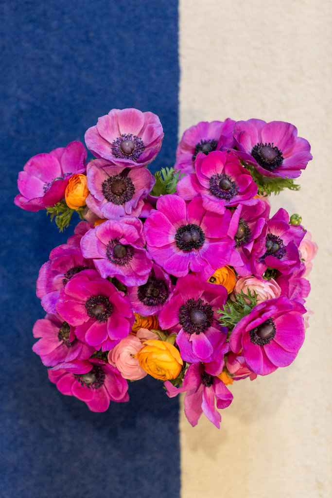 Bright pink flowers on a blue and white rug.
