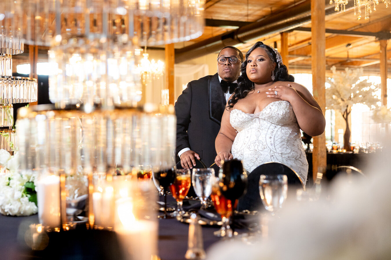 A couple celebrates at their elegant wedding reception under sparkling crystal chandeliers in a luxurious venue at Bibb Mill Event Center