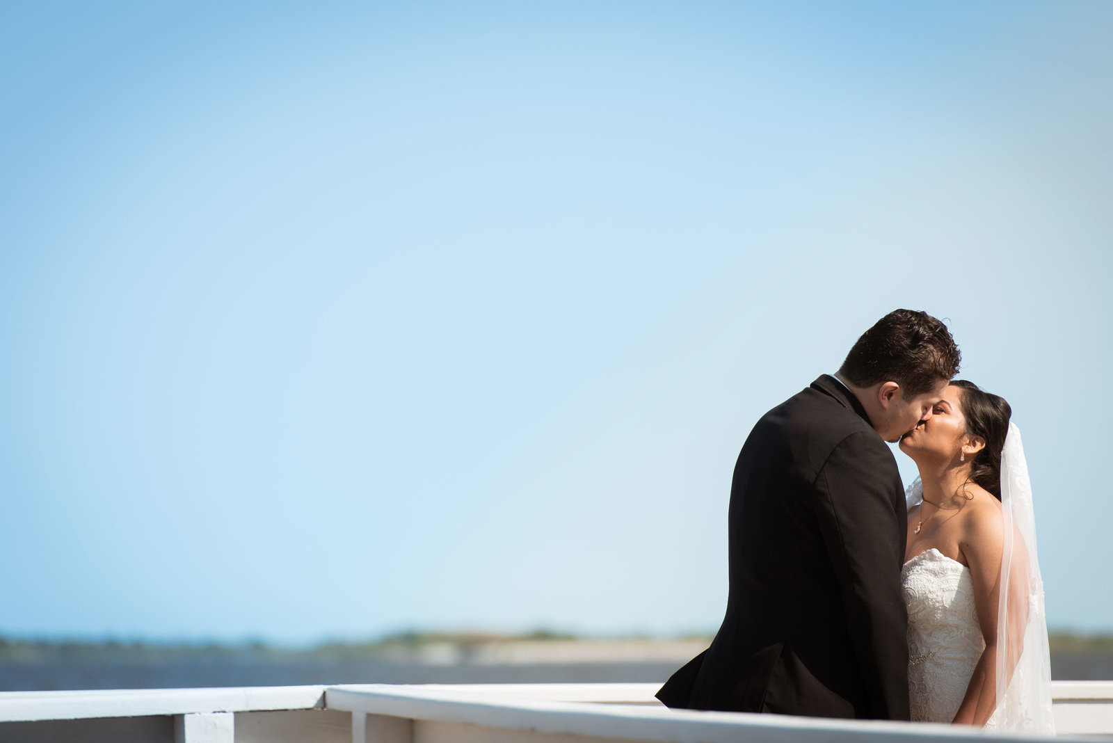 Bride and groom kissing on the dock at Chateau La Mer